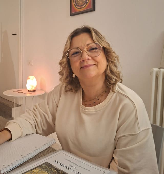 Paola Corsini, sorridente, al tavolo della lezione con la dispensa del corso.