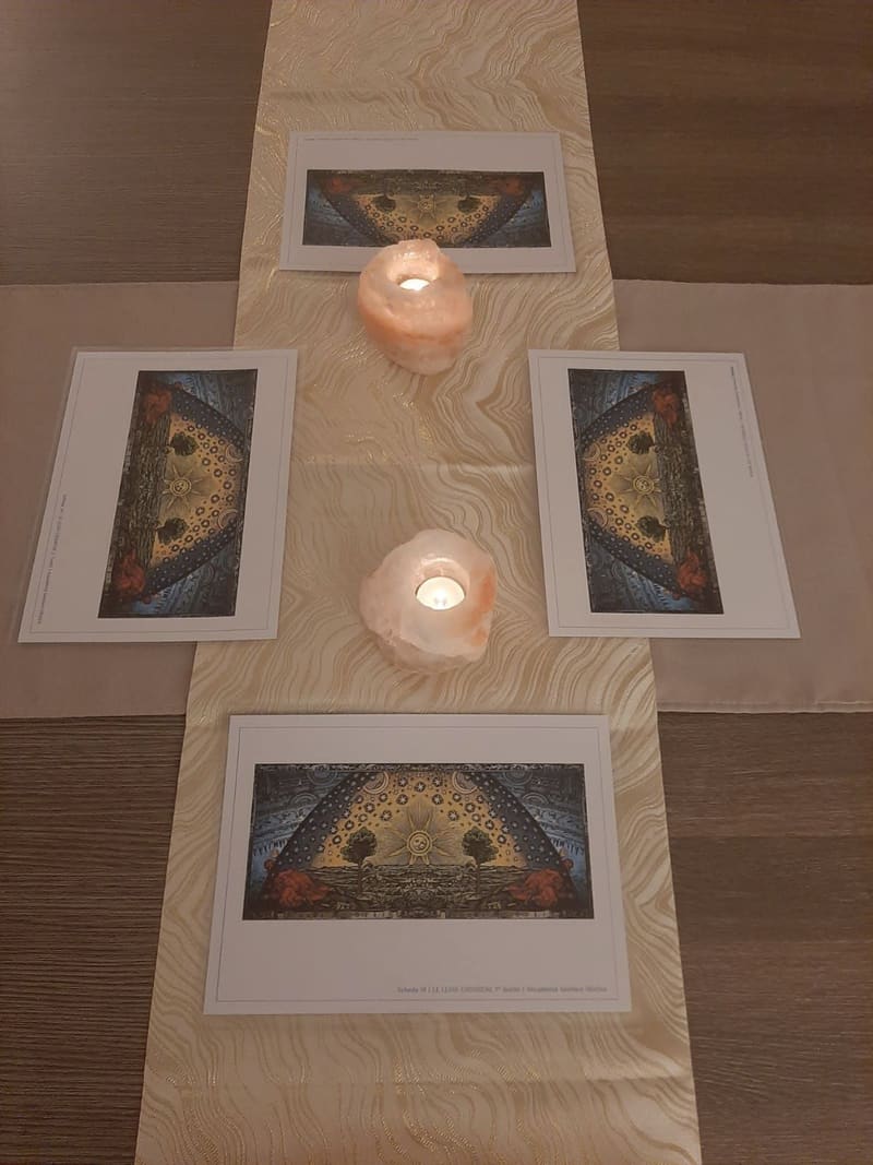 Il tavolo della sala preparato per la lezione, con candele e immagini cosmiche.